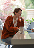 Focused woman working from home at laptop