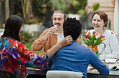 Happy couples enjoying lunch at patio table