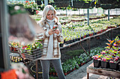 Woman with smart phone shopping in garden shop