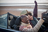 Happy carefree couple in convertible on winter beach