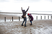 Happy playful couple on wet winter beach