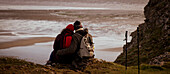 Affectionate hiker couple on cliff over winter beach