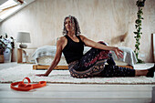 Woman practicing yoga twist on bedroom floor