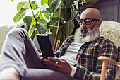 Man with beard using digital tablet at home