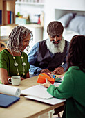 Interior designer showing paint swatches to mature couple