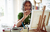 Woman painting at small easel
