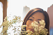 Close up woman looking at white flowers