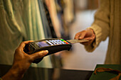Customer with credit card paying at credit card reader