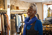 Happy female shop owner in blue scarf in clothing boutique
