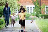 Family with push scooter in driveway