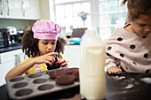 Focused girl baking cupcakes in kitchen