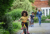 Girl riding bicycle in driveway