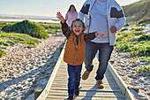 Happy, exuberant boy with Down Syndrome on beach boardwalk