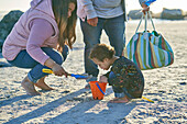 Mother and son playing in sand on sunny beach