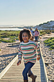 Carefree girl running on beach boardwalk