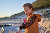 Boy with Down Syndrome playing with bubbles on beach