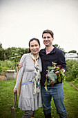 Happy couple with harvested beets in garden