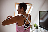 Mature woman in tank top checking smart watch