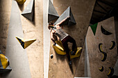 Young woman scaling climbing wall
