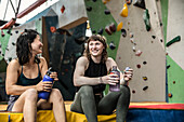 Happy female rock climbers taking a break at climbing gym