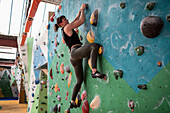 Young female rock climber on climbing wall