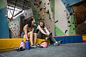 Young female rock climbers preparing in climbing gYm