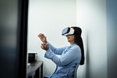 Businesswoman using VR headset in office