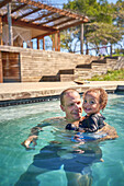 Happy father and toddler son in swimming pool