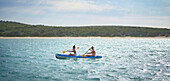 Couple kayaking on sunny lake