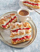 Eclairs with cream and strawberries for coffee