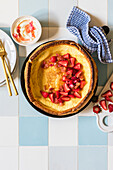 Dutch baby with honey poached rhubarb and fresh stawberries served with mascarpone