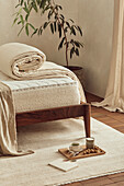 Tray and notepad in front of bed with rolled up slipcover