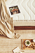 Bird's eye view of magazine on bed and tray on floor