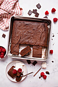 Klassischer Schokoladen-Brownie, serviert mit Himbeeren und Joghurt