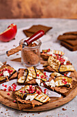 Roggenbrot belegt mit roter Bohnenpaste, gegrillten Auberginen, Granatapfelkernen und Feta-Käse