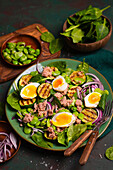 Spinach salad with grilled zucchini, beans, tuna, onions, and egg