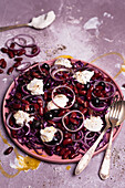 Salad with red cabbage, red beans, red onions, black olives, burrata, and olive oil