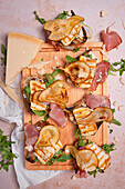 Bread with cream cheese, rocket, Parma ham, grilled halloumi, pear, and Parmesan cheese