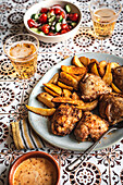 Peri Peri chicken with spicy potato wedges on a tile background