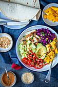 Bowl with chicken, avocado, red cabbage and mango