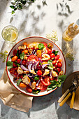 Panzanella with tomatoes, olives, red onions, garlic bread and elderflower vinegar