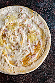 Dosa with chopped red onion (A dosa is a thin batter-based dish originating from South India, made from a fermented batter predominantly consisting of lentils and rice)