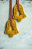 Bell-shaped gingerbread cookies strung on a checkered ribbon