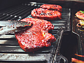 Five Marinated Boneless Pork Chops on a Charcoal Grill