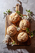 Yeast rolls with flower sprigs on wooden board