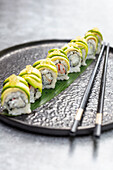 Inside-out sushi rolls with yellow caviar, crab meat and avocado