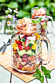 Summer vegetable salad with poultry served in handle cups
