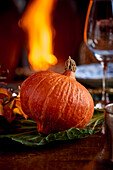 Hokkaido pumpkin as decoration on a table in front of a fireplace
