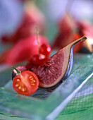 A fig with a tomato and redcurrants