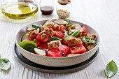 Salad with watermelon and chicken sprinkled with pistachios